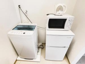 宜野湾市BiBi Hotel FUTENMA的微波炉和洗衣机彼此相邻