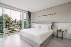 卡塔海滩苏格奥哈那旅馆的一间带白色床的卧室和一个阳台