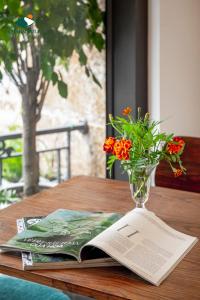 萨帕Charm Hill Sapa Hotel的书和花瓶,放在桌子上