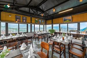 萨帕Charm Hill Sapa Hotel的餐厅设有桌椅和窗户。