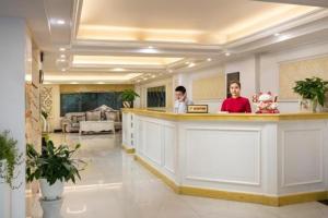 Trương LâmToàn Thắng Hotel - 423 Ngô Gia Tự, Long Biên - by Bay Luxury的两个人站在大厅的柜台上