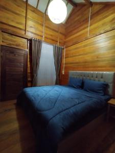 龙目岛库塔Mandalika Queen Hostel的一间卧室配有一张木墙床