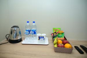 普里Pipul Ocean View Resort的一张桌子,里面装有瓶装水和搅拌机,还有水果