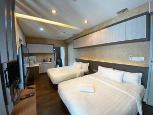 哥打京那巴鲁Aeropod Cactus Rail Suite With Balcony - Kota Kinabalu的酒店客房设有两张床和一台平面电视。