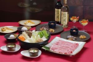 长野原北軽井沢　Golden Forest Hotel的餐桌,带食物盘和一瓶葡萄酒