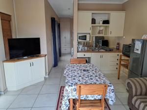 鲸湾港Desert Pearl Self catering & Accommodation的厨房配有桌椅和电视。