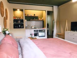 胡志明市65F4 - Sweetheart in Saigon的一间带粉红色床的卧室和一间厨房