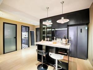 上海大同公寓的厨房配有黑色橱柜和带凳子的台面