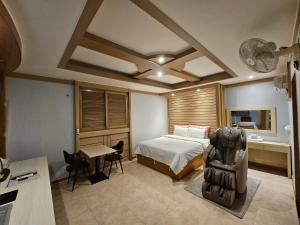 大田Hotel G7 Daejeon的一间卧室配有一张床、一张桌子和一张桌子