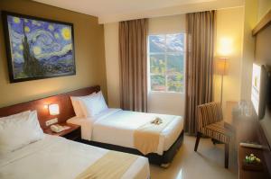 三宝垄三堡垄港奴曼酒店的酒店客房设有两张床和窗户。