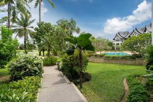 邦涛海滩Spacious 2BR Apartment Allamanda II in Laguna, 10 min from BangTao Beach的一个带人行道和游泳池的花园