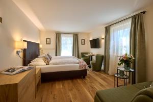 莱赫阿尔贝格Hotel Garni Schneider的配有一张床和一张书桌的酒店客房