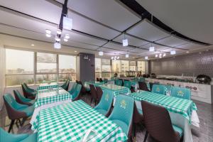 广州翡丽国际酒店的餐厅设有绿色和白色的桌椅