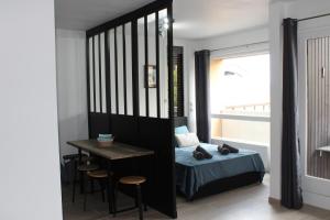 托农莱班Studio centre-ville, proche des thermes的一间卧室配有一张床、一张桌子和一张书桌