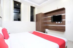齐拉克普尔OYO Hotel Prabhat的一间带两张床和电视的卧室