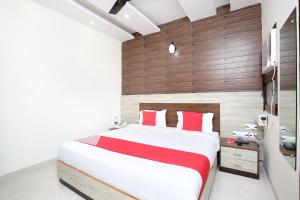 齐拉克普尔OYO Hotel Prabhat的一间卧室配有一张带红色枕头的大床