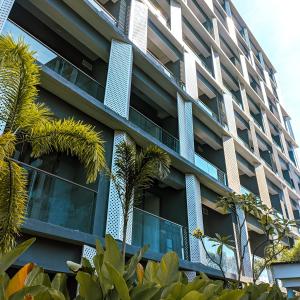 Sepinggang-besarSkylounge Balikpapan by Wika Realty的公寓大楼拥有蓝色窗户和棕榈树