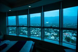 伊斯兰堡Centaurus Hotel Suites的卧室设有窗户,享有城市美景。