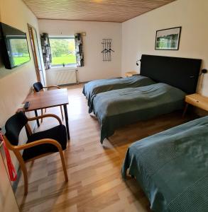 OnsbjergNordgården Pension的一间卧室配有两张床、一张桌子和一张书桌
