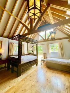 HardhamThe Mill House on the Brooks South Downs West Sussex Sleeps 15的一间卧室设有两张床和横梁天花板。