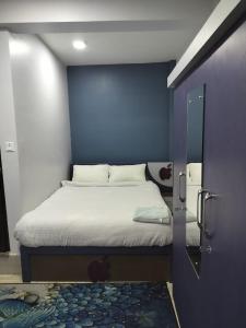 ThimiHotel Homestay Inn的一间卧室配有一张蓝色墙壁的床