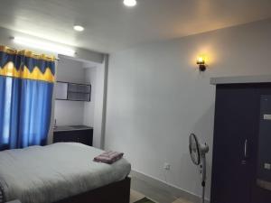 ThimiHotel Homestay Inn的一间卧室配有一张蓝色和黄色窗帘的床