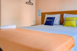 班贾尔马辛Urbanview Hotel AVA Banjarmasin by RedDoorz的一张带蓝色和黄色枕头的床