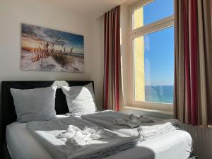 沙博伊茨Zeitlos Hotel Garni的卧室内的一张床铺,设有大窗户