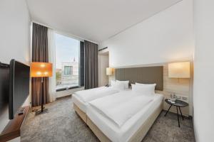 明斯特H4明斯特酒店的卧室设有一张白色大床和一扇窗户。