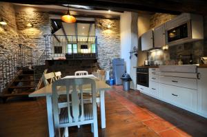 Riols莱斯库迈耶斯度假屋的厨房配有白色的桌子和白色的橱柜。