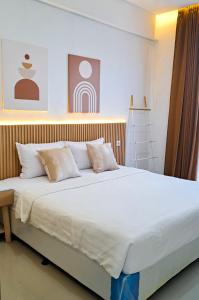 勒吉安Olivia SOHO Guest House的一张配有白色床单和枕头的大床