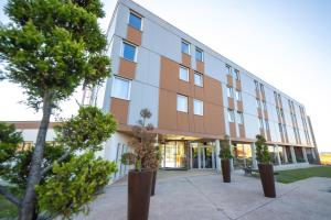 第戎Ibis Styles Dijon Nord Valmy的前面有树木的办公楼