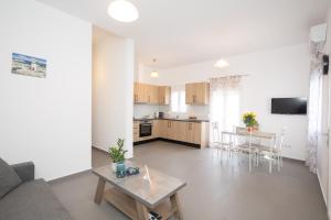 阿格拉瑞Spilia Apartments & Suites Mykonos的客厅以及带沙发和桌子的厨房。