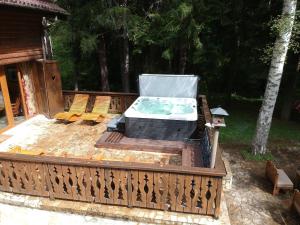 波罗维茨Villa Borovets Mountain & Luxury的甲板上的热水浴池,配有两把椅子
