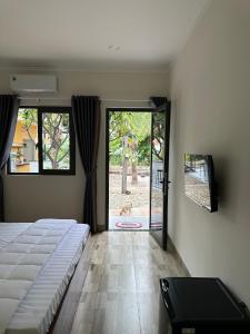 Ninh HảiColor Inn - Homestay & Cafe的一间卧室设有一张床和一个滑动玻璃门