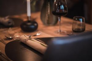 圣洛伦佐-迪塞巴托雷纳尔霍夫活跃/spa/平衡酒店的一张木桌,上面有黑板和一杯葡萄酒