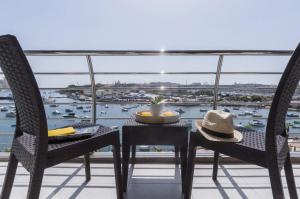 Il- GżiraValletta view Apartments by ST Hotels的阳台享有海港景致,配有桌椅。
