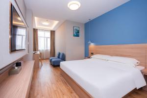 上海上海未来上居酒店的卧室配有一张白色大床和蓝色的墙壁