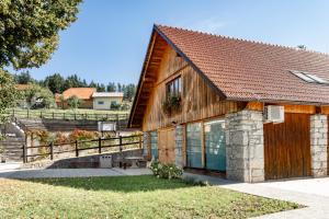 Stari Trg pri LožuYouth Hostel Arsviva的一间木房子,拥有棕色的屋顶
