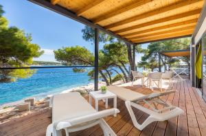 普拉Arena Stoja Camping Homes的一个带桌椅的木制甲板和大海