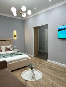 阿斯塔纳ЖК Champion с новым ремонтом的一间卧室配有一张床、一张沙发和一台电视。