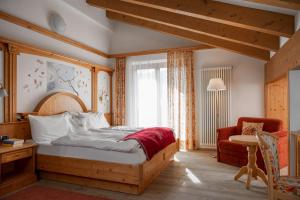 摩德纳迪-坎皮格里奥吉安娜酒店的卧室配有床、椅子和窗户。