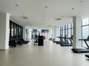 吉隆坡KLCC Suites Platinum 2的一间健身房,里面设有一排跑步机和椭圆机