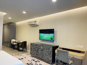 吉隆坡KLCC Suites Platinum 2的一间设有壁挂式电视的房间,配有一张床