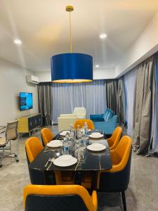 吉隆坡KLCC Suites Platinum 2的一间带桌子和黄色椅子的用餐室