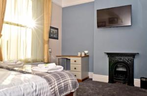 斯托桥The Seven Stars的一间卧室配有一张带壁炉和电视的床。