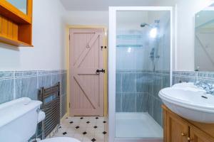 达尔文Midsummer Barn的浴室设有卫生间水槽和粉红色的门。