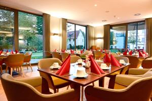 盖瑟克Hotel Rittergut Stoermede的餐厅设有桌椅和红色枕头