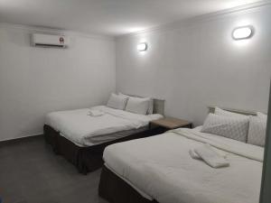 瓜埠Vive Inn的白色墙壁客房的两张床