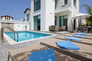 普罗塔拉斯Villa Dina的别墅设有游泳池和庭院家具。